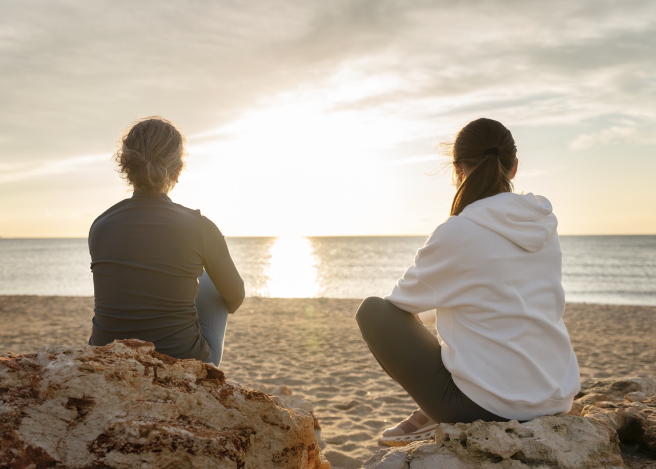 To kvinder i samtale på stranden Mindgo terapeutiske samtaler i naturen for recovery