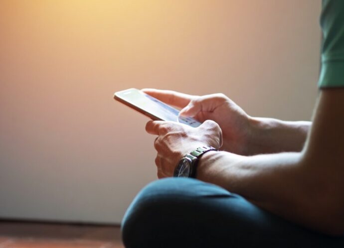 Hipster using a touch screen smart phone hands close up, vintage colors